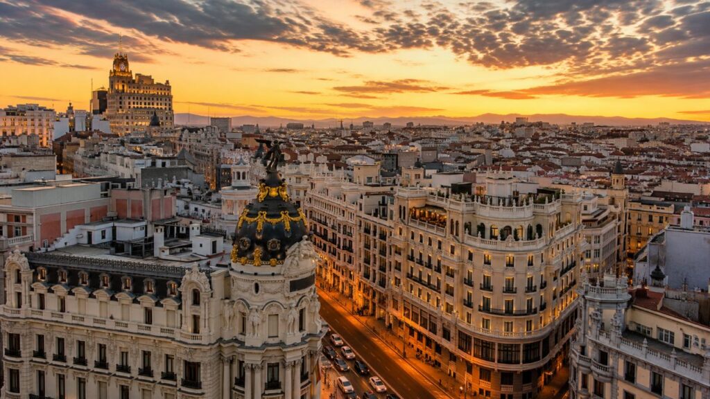 Madrid’i üç günde tüketmeye çalışmayın: Şehri beş parçaya bölün 1 Madrid seyahat rehberi için Gran Vía ve Madrid şehir silüetini gösteren gün batımı manzarası