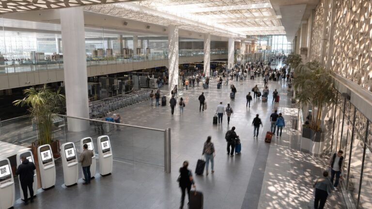 Kahire Havalimanı geliş salonunda dijital vize kiosklarının ve hareket eden yolcuların geniş üst açıdan görünümü