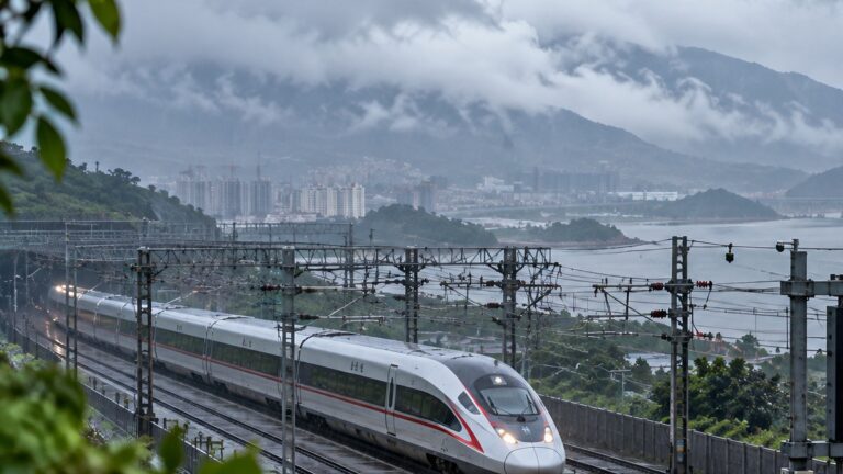Çin tren iptali haberini temsil eden yağmurlu kıyı demiryolu hattındaki yüksek hızlı tren