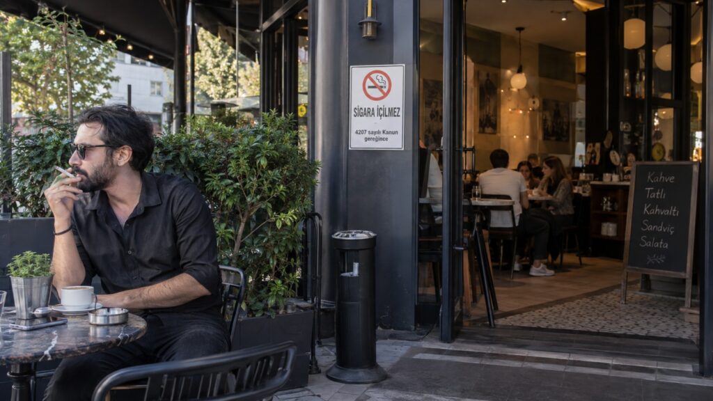 Fumar en Turquía: hombre fuma fuera de un café mientras el interior permanece libre de humo