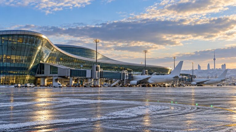 Bakü Havalimanı kış tarifesi haberinde modern terminal önünde iki yolcu uçağı ve pist apronunu gösteren temsili görsel